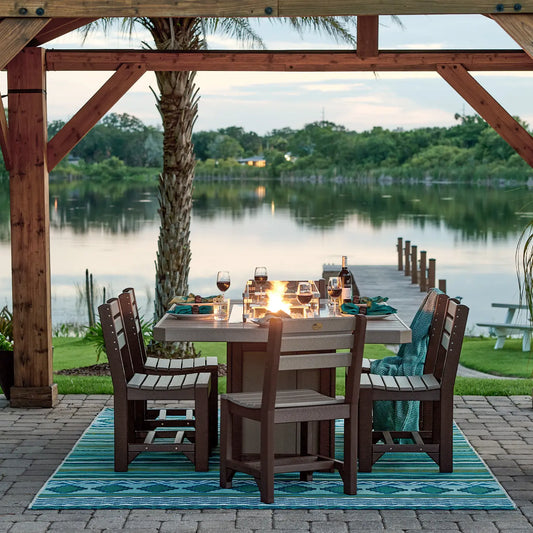 Poly lumber dining set for four on rug under pergola with fire table, lake and trees behind.
