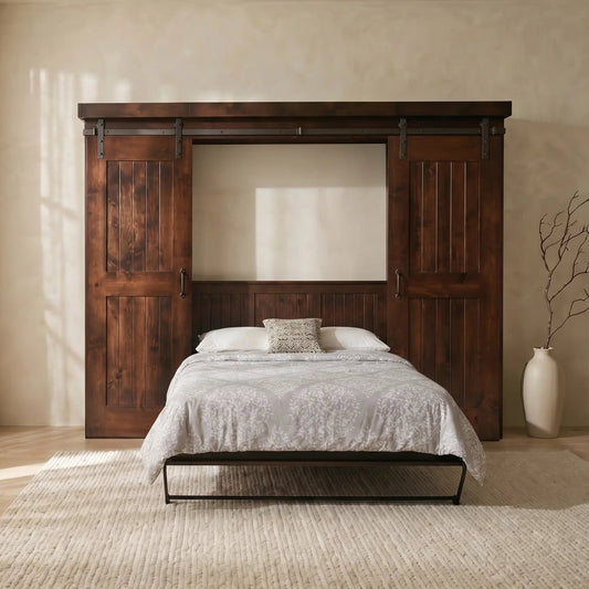 Dark wood Murphy bed with barn doors on beige rug; vase with dried branches to the right.