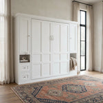 White murphy bed in a room with large windows and a patterned rug on the floor.