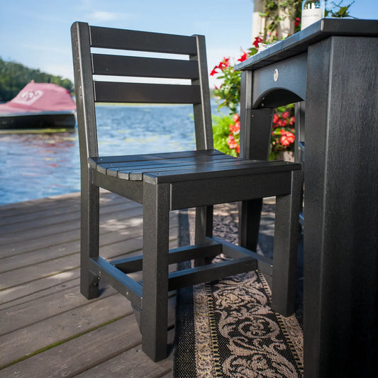 Black Island Side Chair on a dock with rug, lake, red flowers, and jet ski in the background.