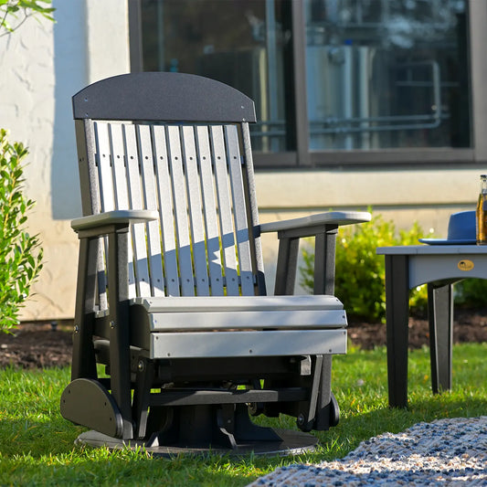 Gray and black swivel glider chair on lawn next to matching seats and side table with drink.