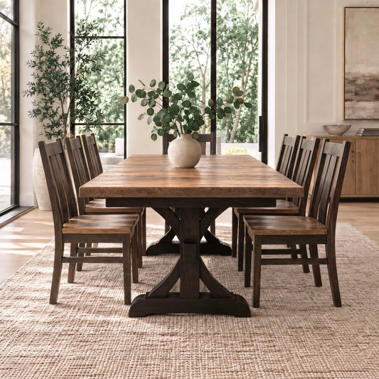 Wooden dining table with six chairs, vase centerpiece, on beige rug near windows and a plant.