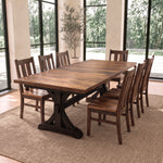 Dining set with 8 chairs on a rug in a bright room with large windows and a potted plant.