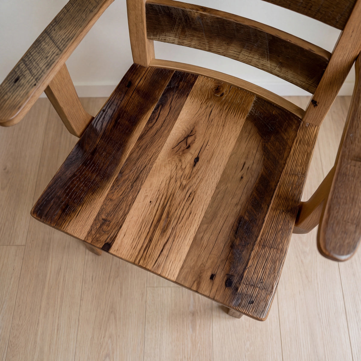 Akron Ladder Back Dining Chair with multi-shade wood seat, viewed from above on wood floor.