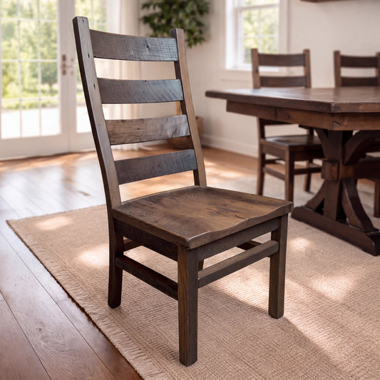 Akron Ladder Back chair of reclaimed barnwood on a rug by windows and greenery in dining room.