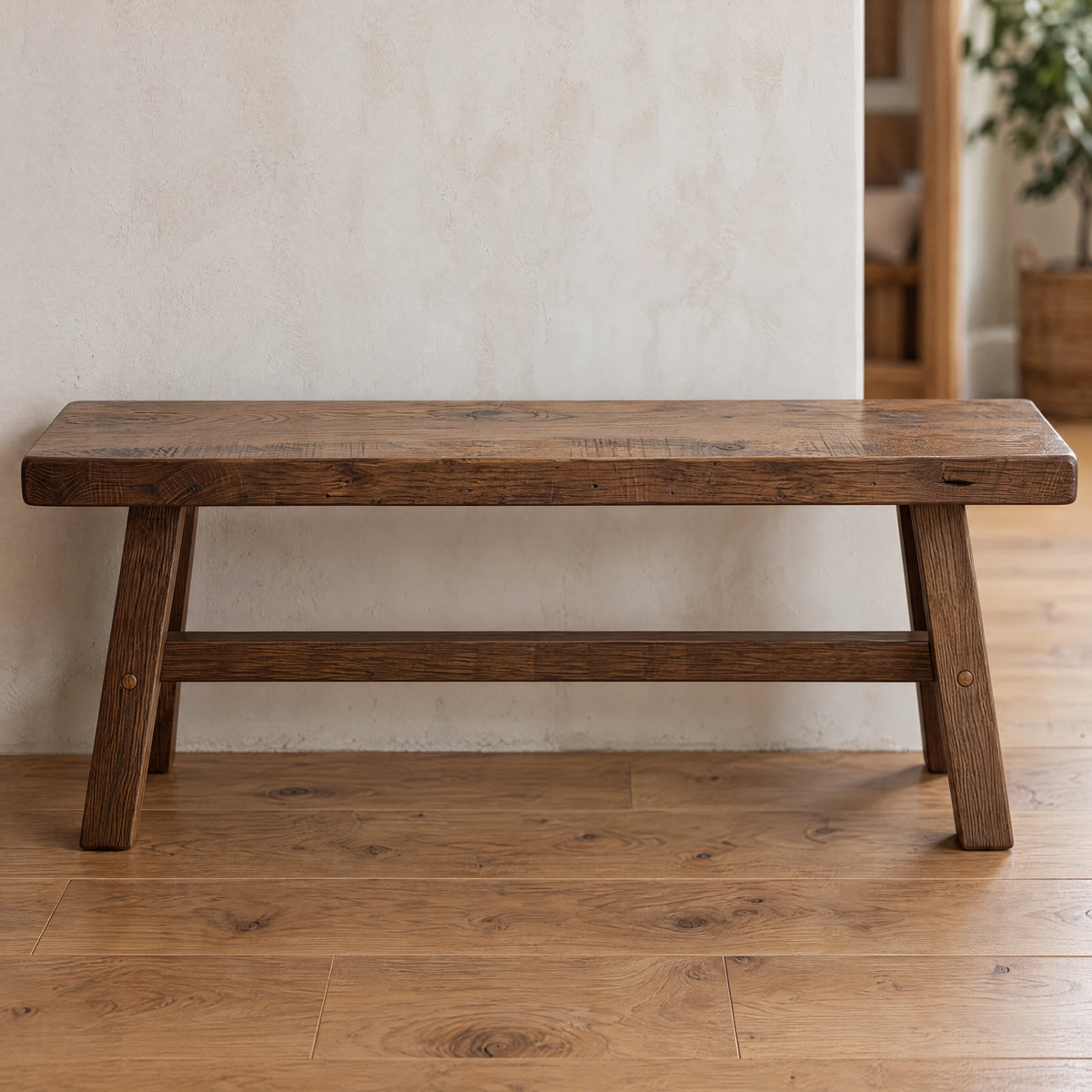 Handcrafted rustic barnwood bench with four tapered legs and a lower support rail.