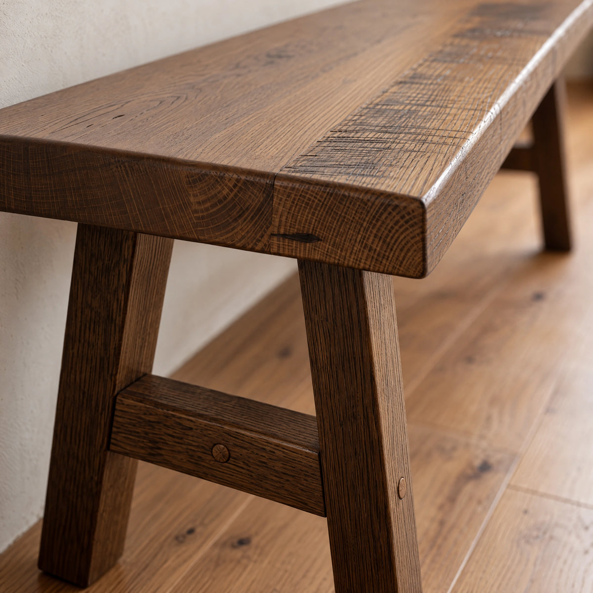 Rustic barnwood bench with a thick, textured seat and splayed legs.