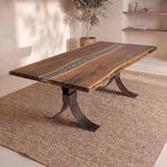 Live edge walnut river dining table with dark stripe, metal legs, and modern, bright decor.