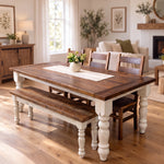 Walden farmhouse dining table with white turned legs, matching bench, and a vase of flowers.