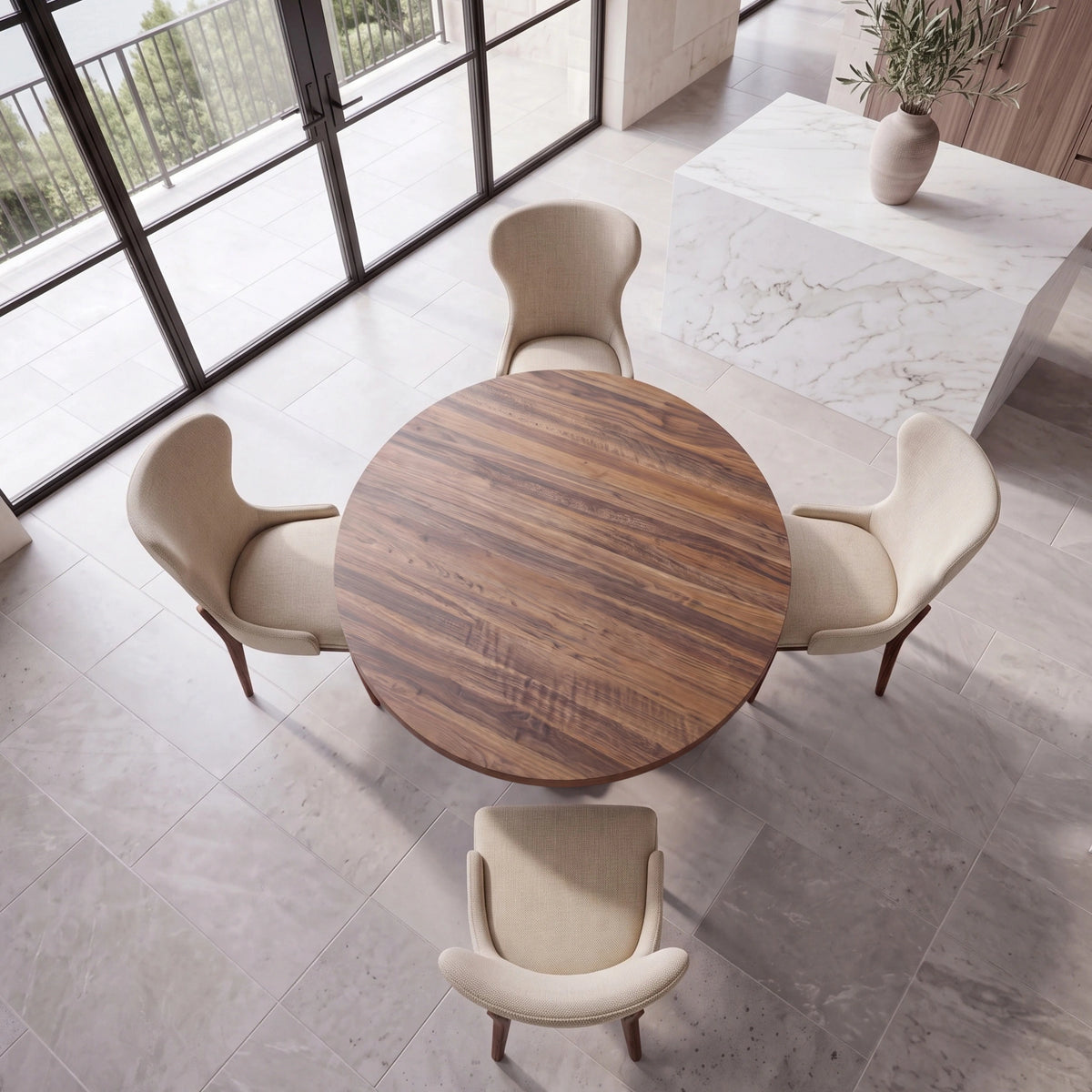 Handcrafted wood dining table with four beige chairs by windows, near marble countertop and vase.
