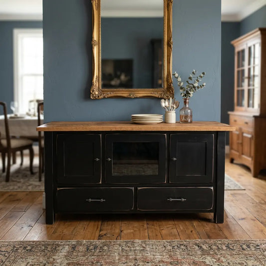 Black buffet with wood top, plates, vase, mirror above; blue walls and dining area in background.