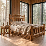 Log bed with beige bedding and nightstand in a cozy cabin room with forest views through large windows.
