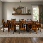 Holbrooke Farmhouse cherry wood dining table with eight chairs on a rug in a sunlit room, shelf with decor behind.