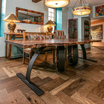 Wooden dining table with unique steel metal base in a room 
