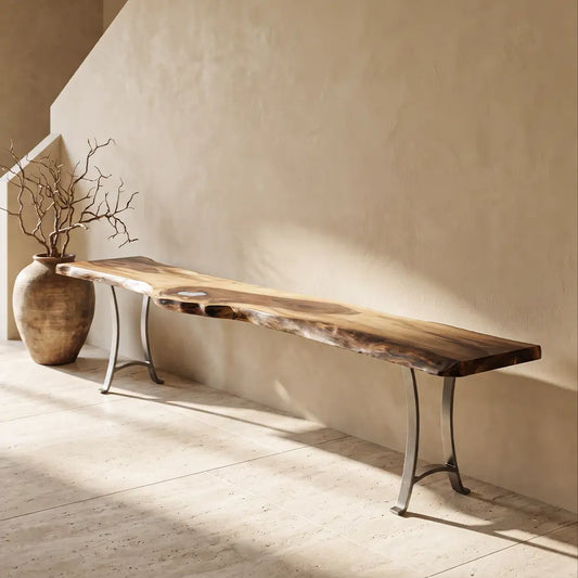 Long walnut-epoxy console, ceramic vase with dried branches by staircase on beige wall.