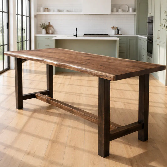 Live edge walnut counter table in sunlit modern kitchen with green cabinets and white counters.