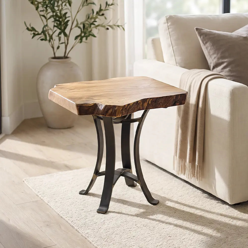 Live edge sycamore end table on beige rug by cream sofa and plant in sunlit room.