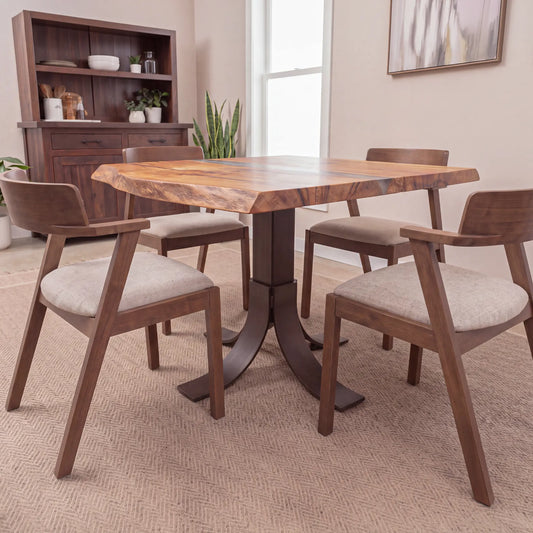 Modern dining room with oak epoxy table, cushioned chairs, cabinet, plants, and sunlight.