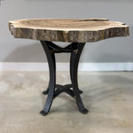 Live edge walnut end table with black steel legs on concrete floor by gray wall and white trim.