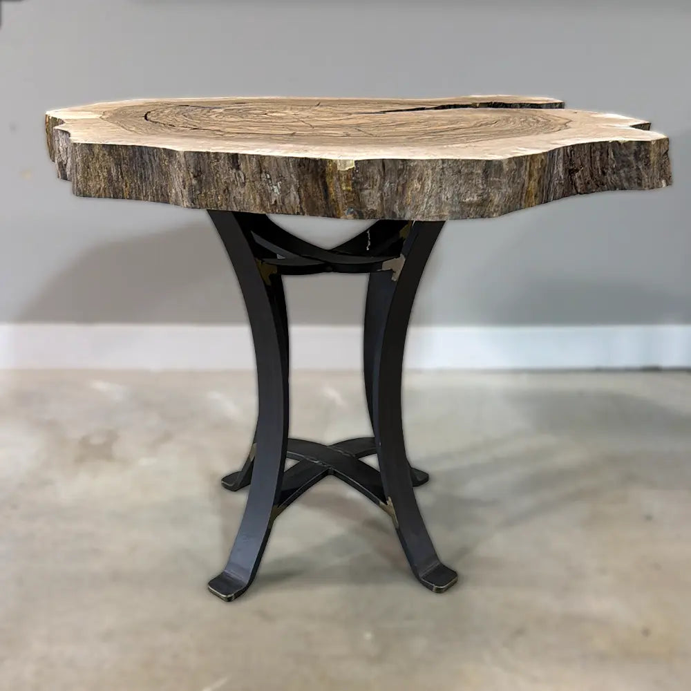Live edge walnut end table with black steel legs on concrete floor by gray wall and white trim.