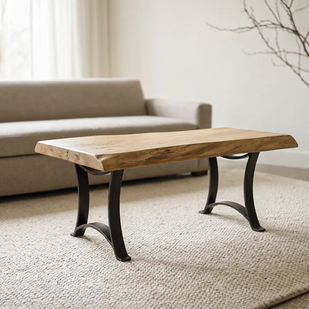 Live edge maple coffee table on beige rug, in front of gray sofa and window in a minimalist room.